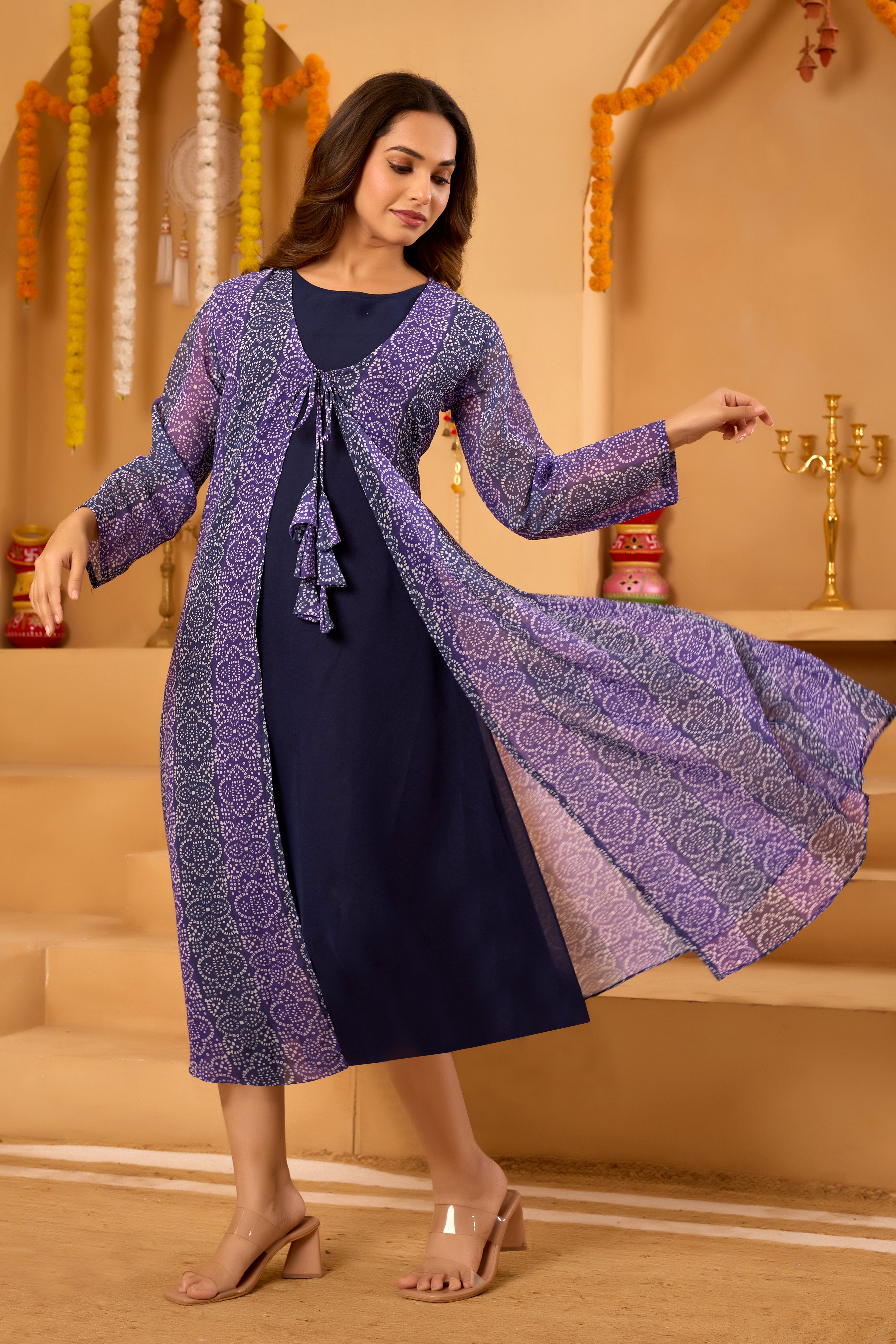 Woman wearing a purple patterned jacket over a navy dress 