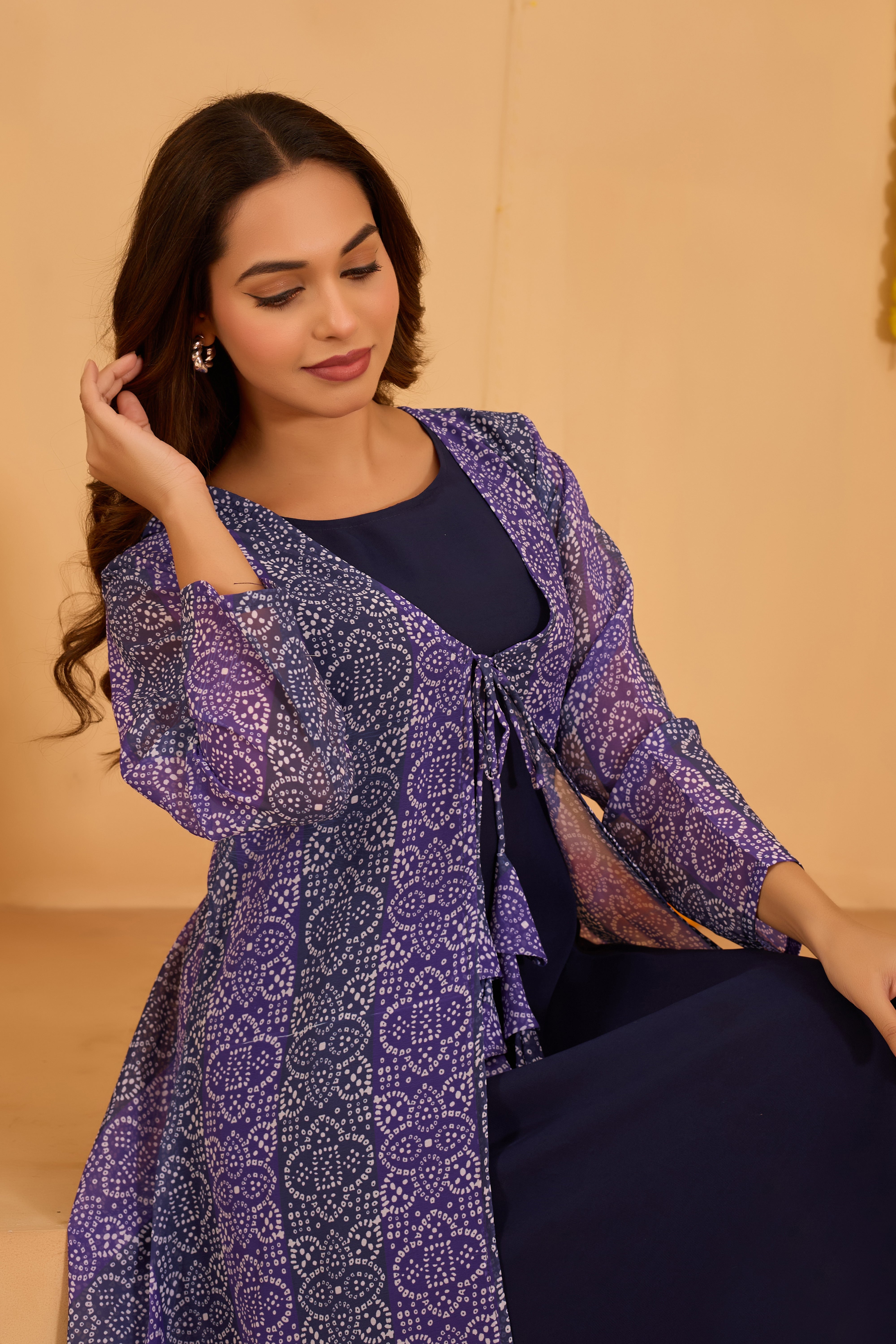 Woman wearing a purple patterned jacket over a dark top 