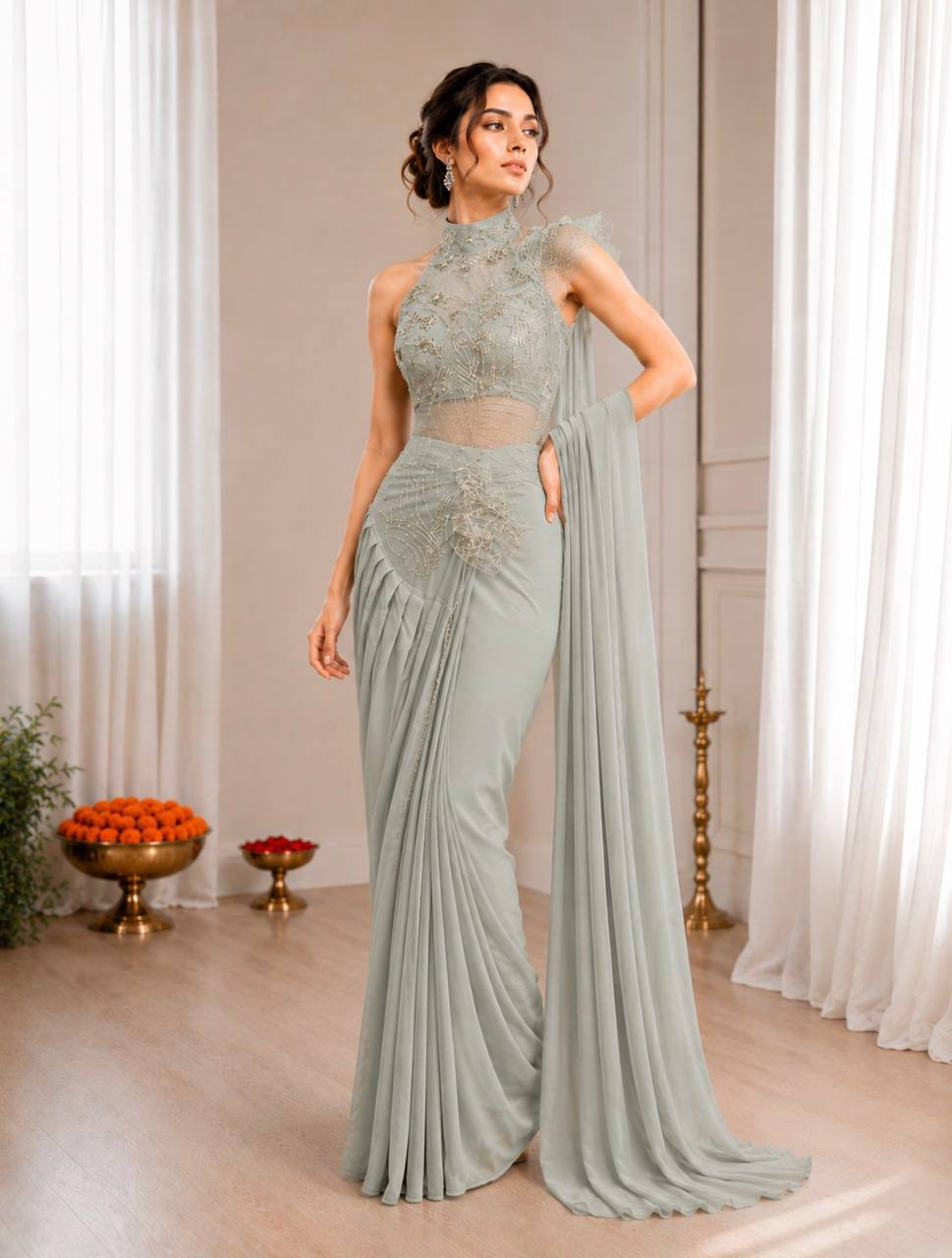 A woman models a floor-length sage green evening saree